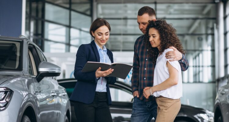 casal se perguntando para atendente com quantos km deve vender o carro